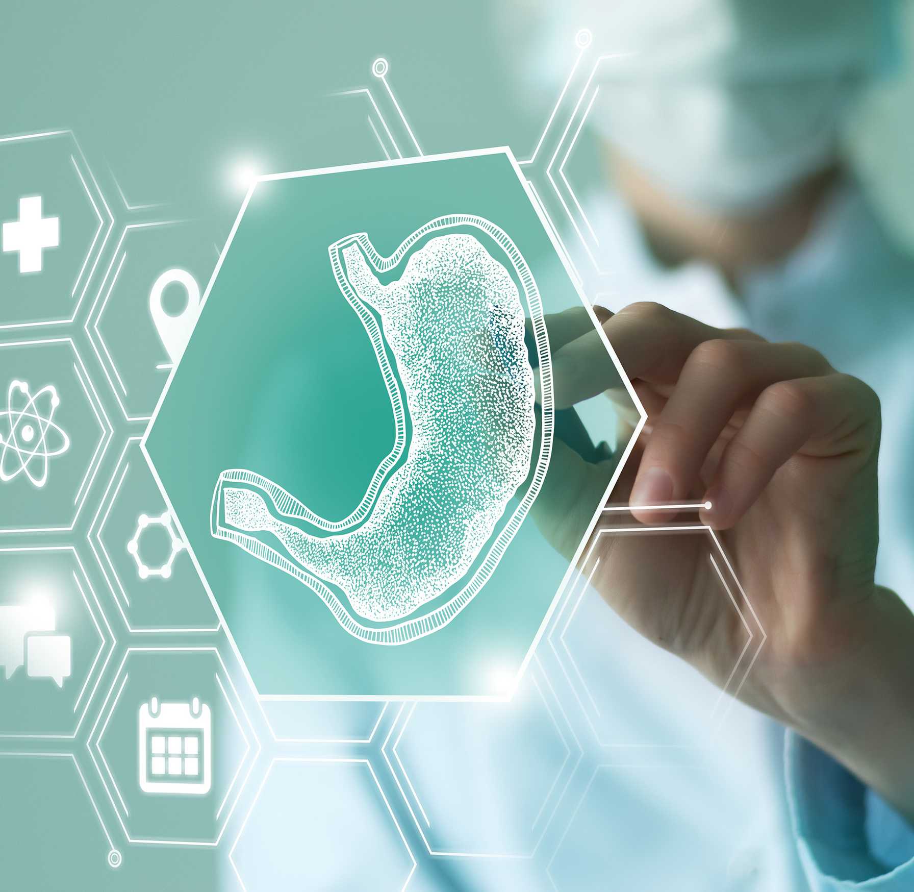 A medical professional interacts with a digital interface displaying a holographic image of a human stomach, surrounded by various healthcare and science-related icons, representing advanced gastrointestinal diagnostics or technology.